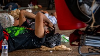 A person in Phoenix, Arizona lays on the floor of a cooling center during a July 2023 heat wave