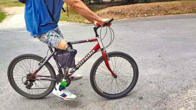 A man wears a prosthetic leg while riding a bicycle