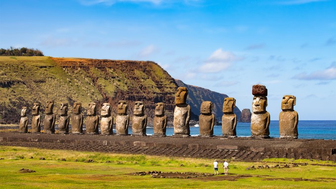 A line of the famous Easter Island stone statues face inland, their backs to the ocean.