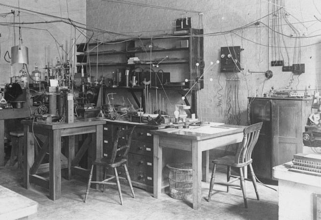 old black and white photo of a lab with wooden desks and shelves