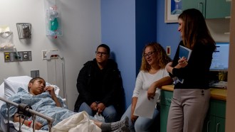 image of Erica Esrick in a hospital room speaking with Helen Obando and her family