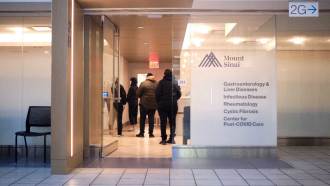 Four patients line up at a desk in Mount Sinai's Center for Post-COVID Care