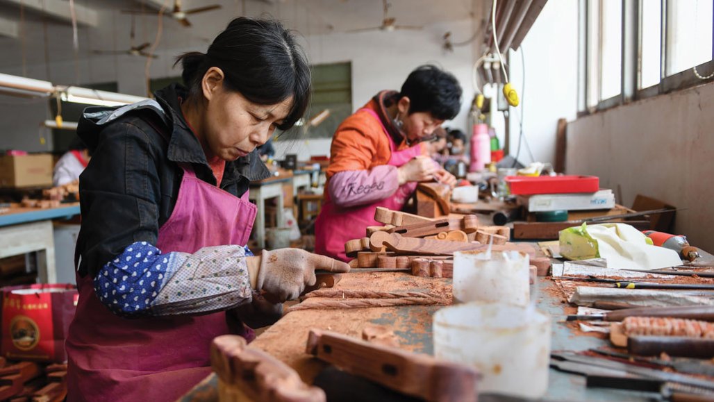 Artisans carving rosewood