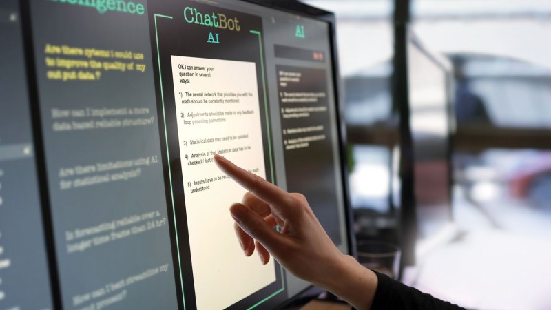 A photo shows someone's hand using an ai chatbot touch screen.