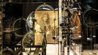 Telescope lenses in front of a portrait of astronomer Christiaan Huygens