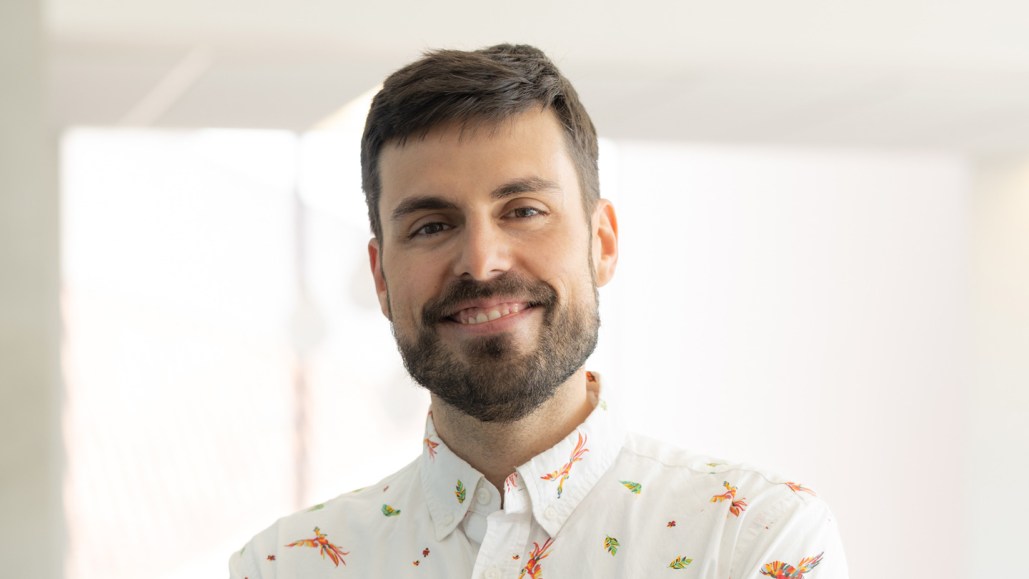 A headshot of theoretical physicist Julian Muñoz against a brightly lit backdrop